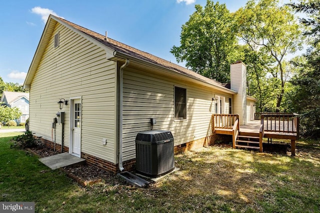 back of property featuring a wooden deck, central air condition unit, and a lawn