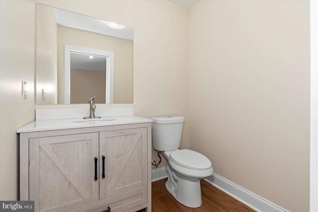 bathroom with vanity, wood-type flooring, and toilet