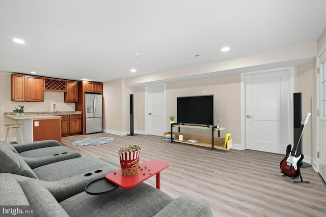 living room with indoor wet bar and light wood-type flooring