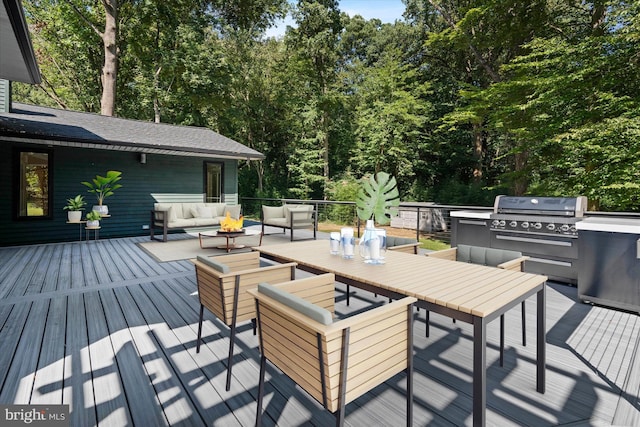 wooden deck with an outdoor living space and exterior kitchen