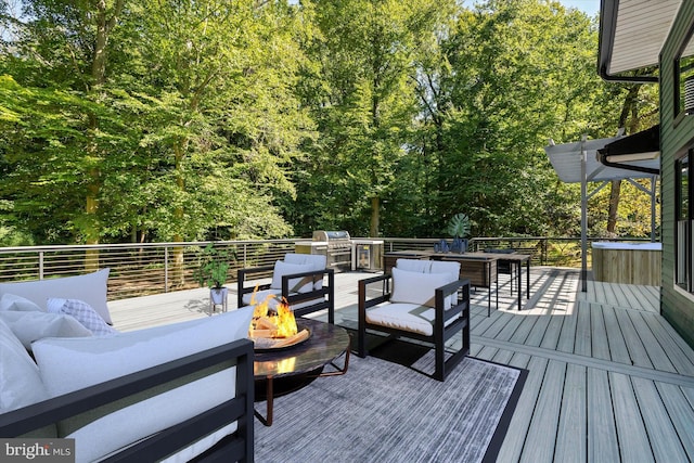 wooden deck featuring grilling area and an outdoor living space with a fire pit