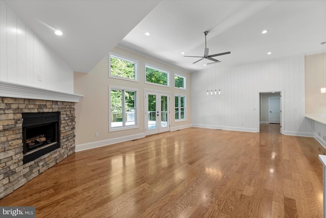 unfurnished living room featuring ceiling fan, a fireplace, and light hardwood / wood-style floors