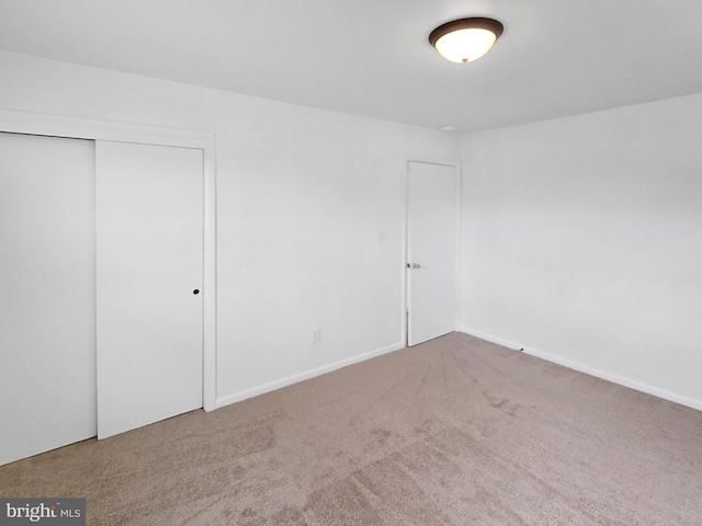 unfurnished bedroom featuring carpet floors and a closet