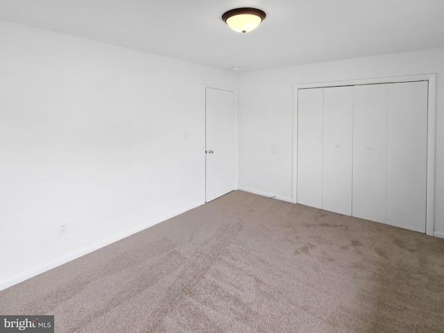 unfurnished bedroom featuring carpet and a closet