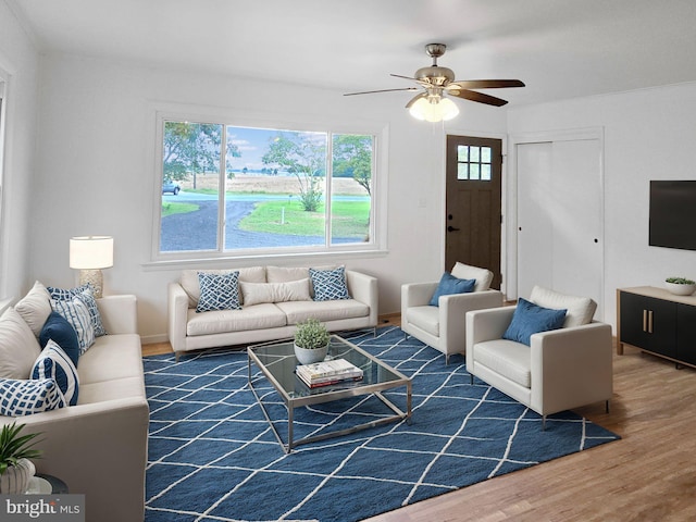 living room featuring dark wood-type flooring and ceiling fan