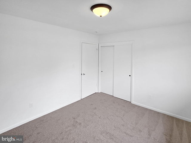 unfurnished bedroom featuring carpet floors and a closet