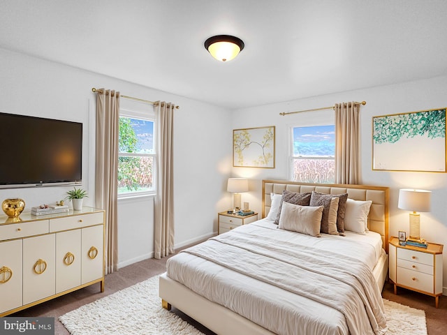 bedroom featuring dark colored carpet and multiple windows