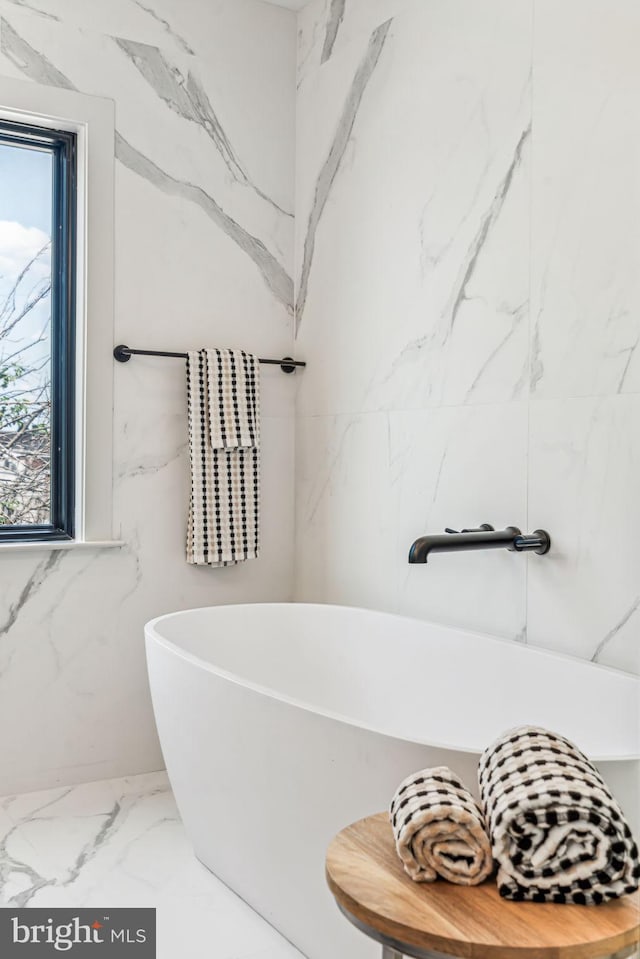 bathroom featuring tile walls and a tub