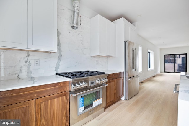 706 Latona St Unit F, Philadelphia, PA 19147 - kitchen with premium appliances, light wood-style flooring, brown cabinets, and decorative backsplash