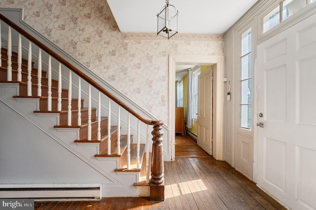 entryway featuring baseboard heating, dark wood-type flooring, and a healthy amount of sunlight