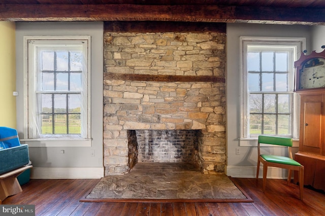 living room with dark wood-type flooring, plenty of natural light, and a fireplace