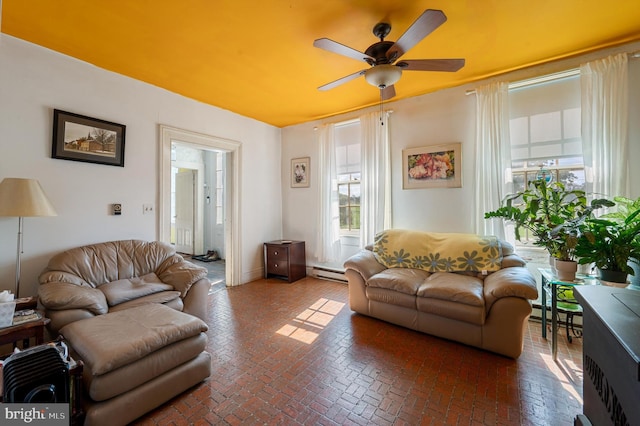 living room with a baseboard heating unit and ceiling fan