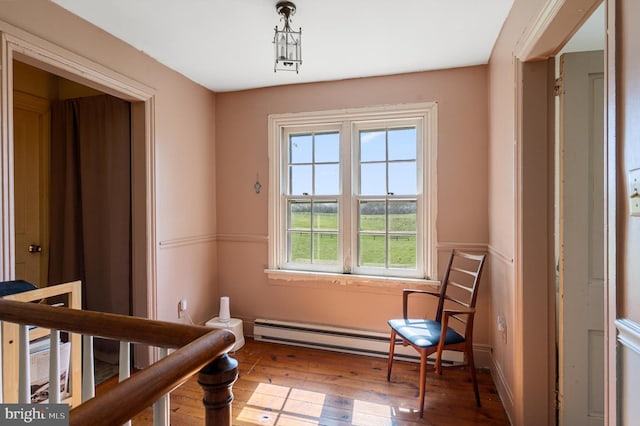 living area featuring hardwood / wood-style floors and baseboard heating