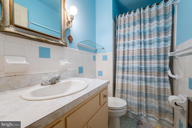 bathroom with tile walls, vanity, and toilet