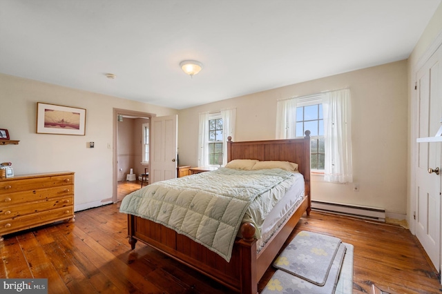 bedroom featuring baseboard heating and hardwood / wood-style flooring