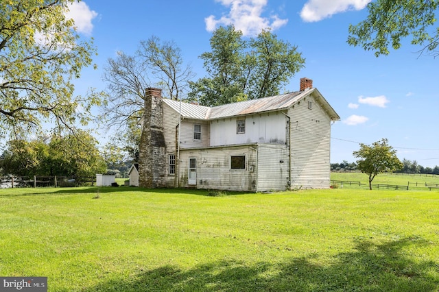 rear view of property with a yard