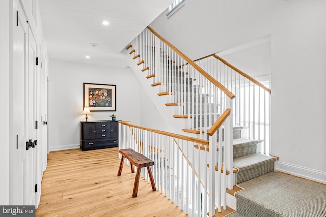 stairs featuring wood-type flooring and a healthy amount of sunlight