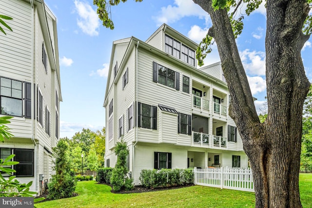 view of front of house with a balcony and a front yard