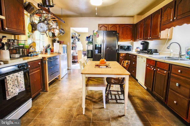 kitchen with appliances with stainless steel finishes, sink, and a breakfast bar area