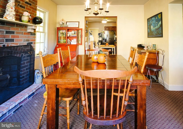 carpeted dining room with an inviting chandelier and a fireplace