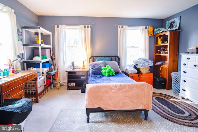 bedroom featuring multiple windows and light colored carpet