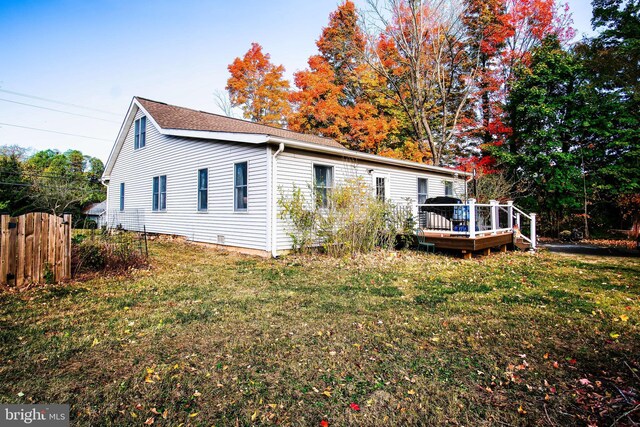 exterior space with a yard, a deck, and fence