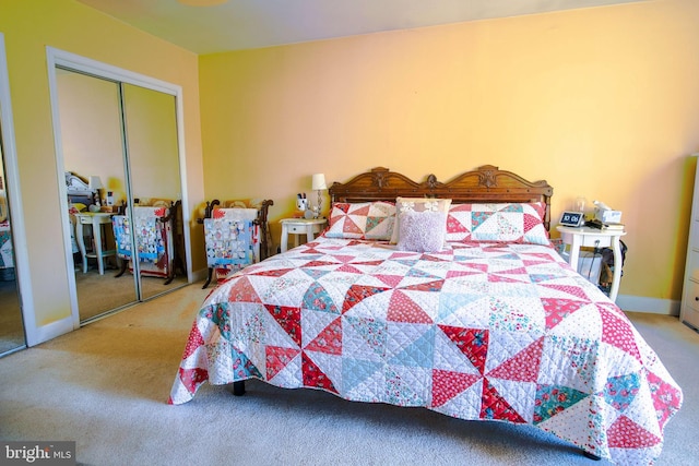 carpeted bedroom with a closet and baseboards