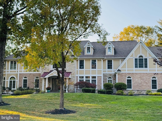 tudor home featuring a front lawn