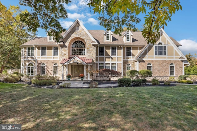 english style home featuring a front lawn and a balcony