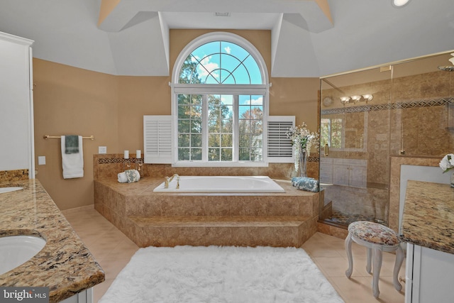 bathroom with a towering ceiling, tile patterned flooring, vanity, and a relaxing tiled tub