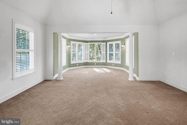 unfurnished living room featuring light colored carpet, a healthy amount of sunlight, and decorative columns