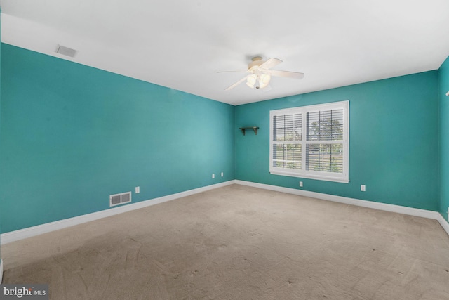 empty room featuring light colored carpet and ceiling fan