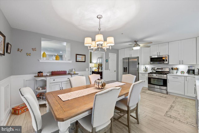 dining room with ceiling fan with notable chandelier and light wood-type flooring