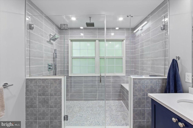 bathroom with a shower with shower door and vanity