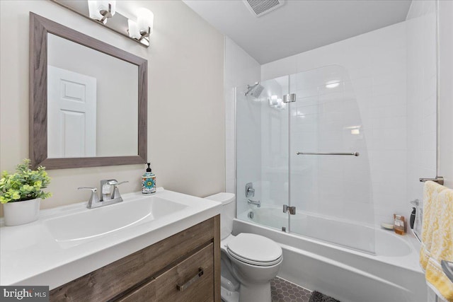 full bathroom featuring shower / bath combination with glass door, toilet, and vanity