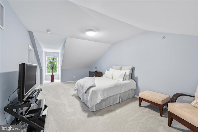 bedroom featuring vaulted ceiling and light colored carpet