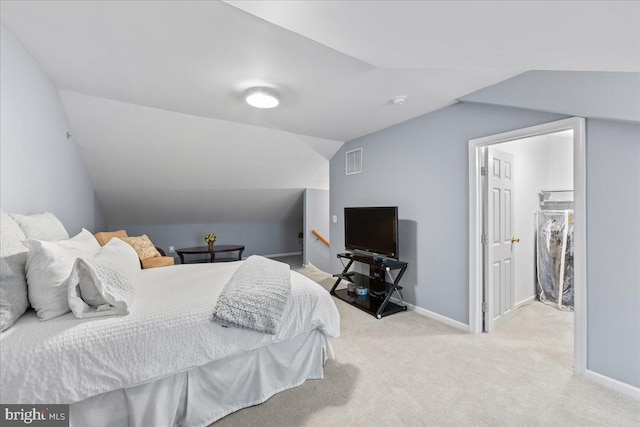 bedroom featuring vaulted ceiling and light carpet