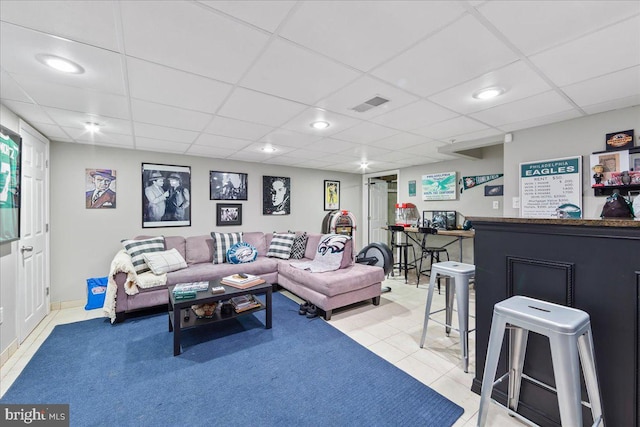 tiled living room featuring a drop ceiling