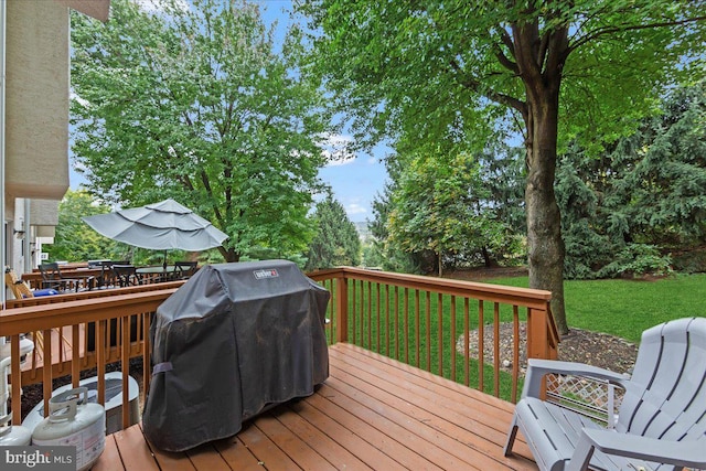 wooden deck featuring area for grilling and a lawn