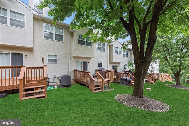 back of house with a deck, a yard, and central air condition unit