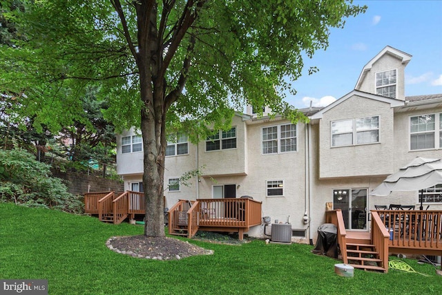 back of property featuring a wooden deck, cooling unit, and a lawn