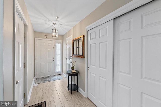 entrance foyer with an inviting chandelier and light hardwood / wood-style flooring