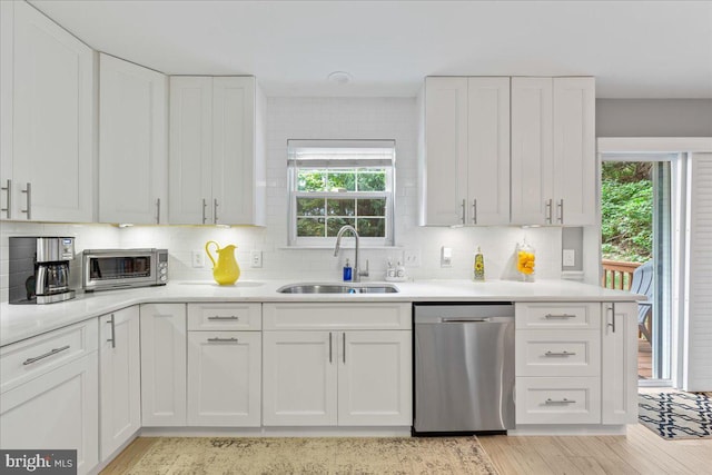 kitchen with dishwasher, light wood-type flooring, sink, and white cabinetry