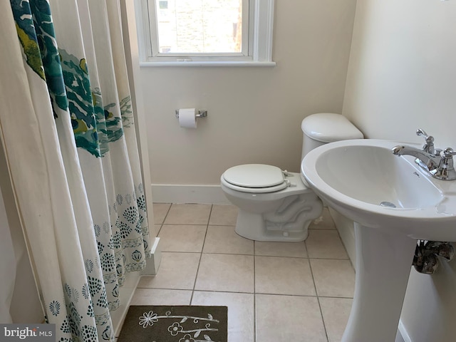 bathroom featuring tile patterned flooring, walk in shower, and toilet