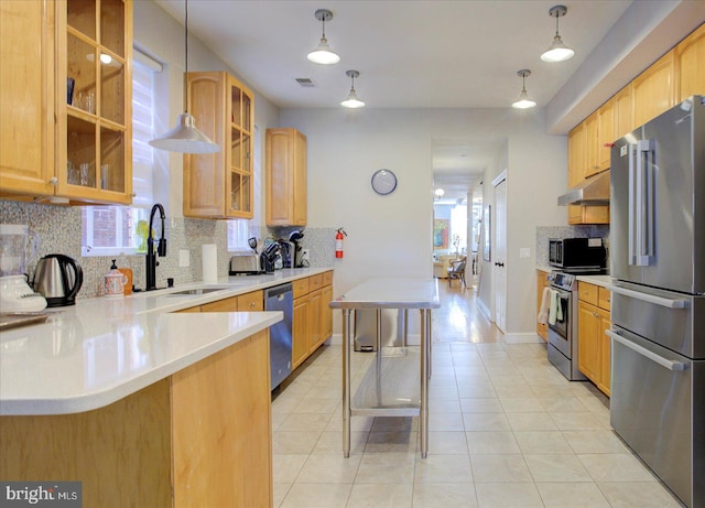 kitchen with appliances with stainless steel finishes, plenty of natural light, a kitchen bar, and decorative backsplash