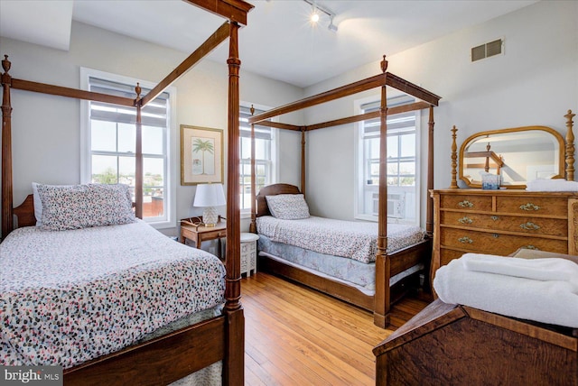 bedroom featuring rail lighting and light hardwood / wood-style floors