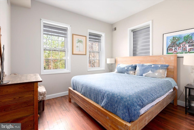 bedroom with dark hardwood / wood-style floors