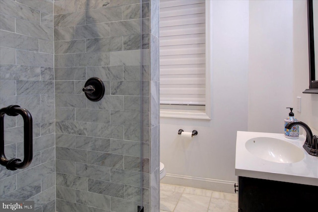 bathroom with a tile shower, vanity, and toilet