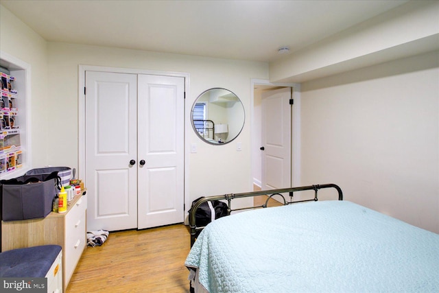 bedroom with light hardwood / wood-style flooring and a closet