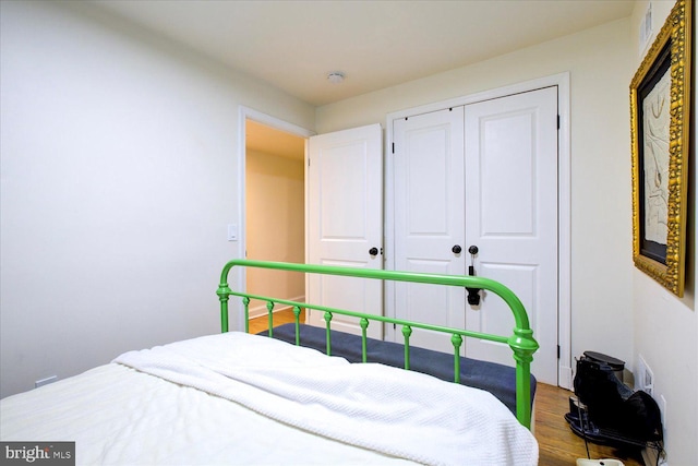 bedroom with hardwood / wood-style flooring and a closet